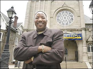 The Rev. Ray A. Barnard in front of the Impacting Your World Christian Center on Germantown Avenue. The growing church has 2,000 members.
